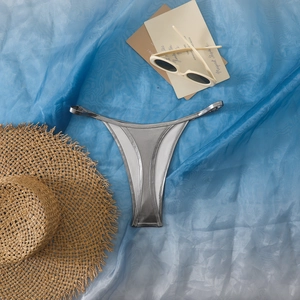 Detailaufnahme des silbernen Metallic-Bikini-Slips mit schmalen Trägern und Welleneffekt-Dekor