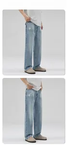 Détail d'un jean bleu clair délavé avec genoux déchirés et coupe droite décontractée
