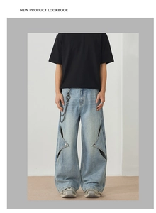 Close-up of light blue wide-leg denim jeans featuring hollow-out diamond cutouts and studs