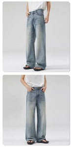 Detail view of men's wide-leg jeans showing washed light blue denim and cat-whisker texture