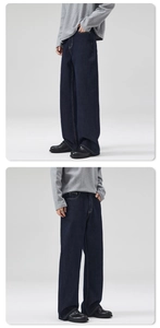 Detail view of deep indigo loose fit jeans with yellow contrast stitching for men