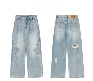 Detail of light blue wide-leg jeans featuring star-shaped cutouts and metal eyelets