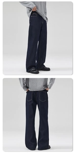 Detail of dark indigo raw denim straight leg pants with contrast orange stitching