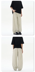 Detail view of khaki cotton wide-leg pants featuring loose fit and stacked cuffs style