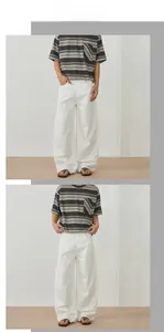 Detail view of white relaxed-fit mercerized cotton trousers with smooth drape and clean seams