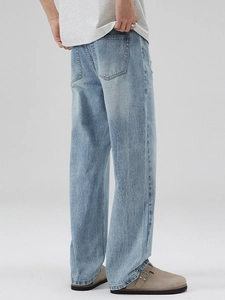 Jean en denim délavé bleu clair pour hommes coupe droite et ample vue de dos en studio