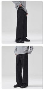 Detail view of wide-leg black denim pants with contrast stitching and straight-cut design