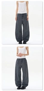 Detail view of dark grey wide-leg trousers with stone-washed texture and seam details