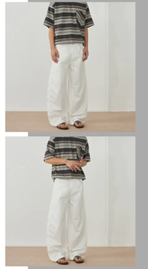 Close-up of white wide-leg casual pants paired with a striped short-sleeve pocket t-shirt