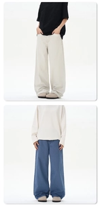 Detailed close-up showing the premium texture and loose fit of cream-white denim pants