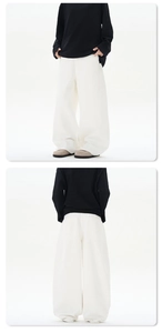 Vue verticale d'un pantalon blanc large à coupe ample avec effet d'ourlet empilé