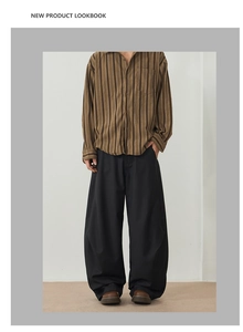 Detail of loose fit black trousers with vertical striped shirt for a modern casual look