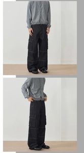 Detail shot of wide-leg cargo jeans showing side flap pockets and contrast stitching accents