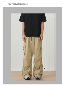Detail of khaki outdoor cargo pants with large flap pockets and drawstring hem