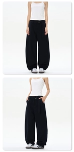 Detail view of black baggy cotton trousers with matching fabric belt in streetwear style