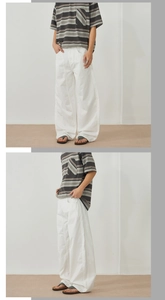 Macro shot of white wide-leg trousers featuring soft cotton-linen blend fabric texture
