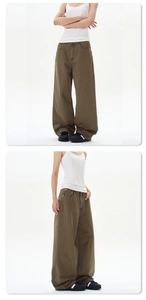 Detail view of olive green wide-leg trousers featuring heavy cotton fabric and cargo style
