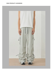 Detail view of light grey cargo pants featuring adjustable drawstring cuffs and large side pockets