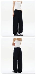 Detail view of high waist black wide leg trousers paired with white ribbed cotton camisole