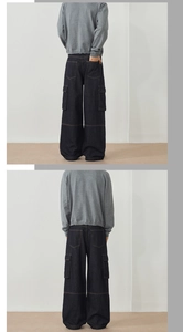 Detail shot of vintage loose fit denim cargo pants with side pockets and orange stitching