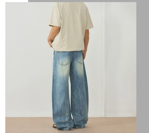 Vue arrière du jean large délavé bleu clair avec détails usés et moustaches de chat effet