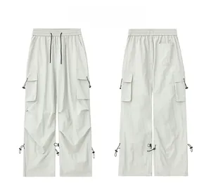 Detail view of light gray outdoor cargo pants with elastic drawstring waist and flap pockets