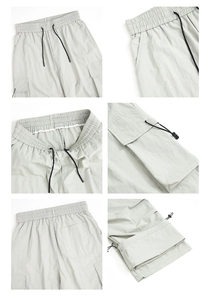 Detail view of light grey cargo pants showing elastic drawstring waist and side pockets