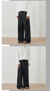 Détail de la chemise blanche à rayures verticales et du pantalon large noir pour hommes
