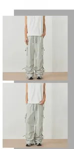 Detail of light grey cargo pants showing side pockets and adjustable drawstring hem