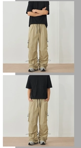 Detail of khaki cargo pants featuring large side pockets and adjustable drawstring hems