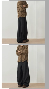 Detail view of brown vertical stripe shirt and black wide-leg trousers on a model