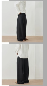 Détail du pantalon large noir pour homme avec un tombé fluide et une texture premium