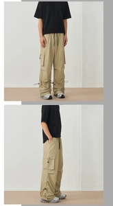 Detail view of khaki stretch cargo pants with multiple utility pockets and drawstring hem