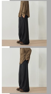 Detail view of baggy black trousers with vertical stripe shirt in retro casual style