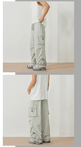 Detail of light grey cargo pants showing side utility pocket and adjustable drawstring hem
