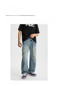 Modello maschile che indossa jeans azzurro chiaro effetto invecchiato con strappi