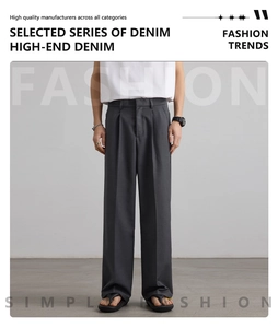 Detailed view of dark grey wide-leg trousers with pressed pleats and premium fabric texture