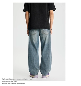 Dettaglio dei jeans larghi effetto consumato con tasche posteriori e lavaggio azzurro