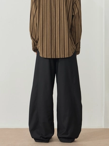 Back view of brown vertical striped shirt paired with loose black wide-leg trousers