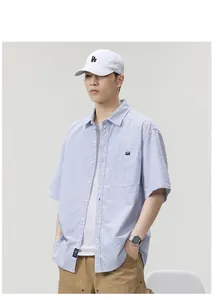 Close-up of blue striped short sleeve shirt featuring chest pocket and brand label detail