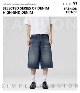 Detail shot of loose-fit blue washed denim shorts featuring street style whiskers