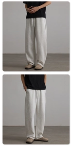 Close-up of light grey wide-leg sweatpants showing vertical seam and drawstring detail