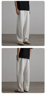 Detail view of light grey heather sweatpants featuring drawstrings and vertical seams