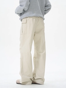 Détail de la poche cargo sur le pantalon beige à coupe droite et texture premium