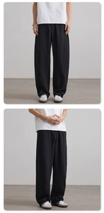Detail of black baggy sweatpants showing the drawstring waist and curved seam stitching