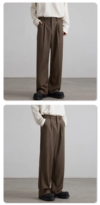 Detail view of brown wide-leg trousers featuring front pleats and draped fabric texture