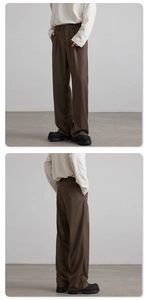 Detail of dark brown straight leg trousers with pleated waist and premium draped fabric