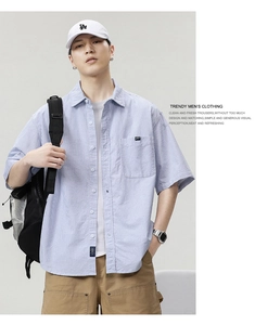 Detail of blue and white striped short sleeve shirt featuring a chest pocket and buttons