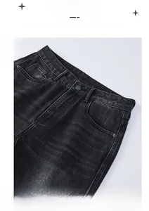 Detail view of the washed black-gray denim waist with metal buttons and stitched belt loops