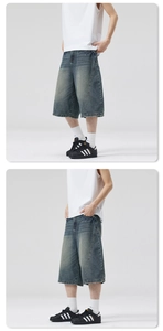 Detail of vintage washed denim shorts showing lightning seam design and raw hems
